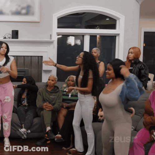 A Group Of Women Are Gathered In A Living Room With The Word Zeus On The Bottom Left GIF