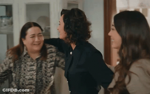 A Group Of Women Are Hugging Each Other And Laughing GIF