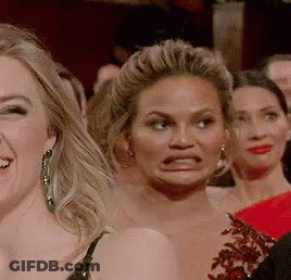 A Group Of Women Are Making Funny Faces In A Crowd . GIF