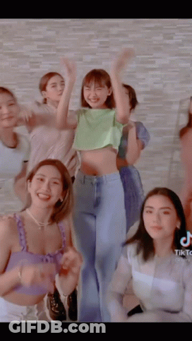 A Group Of Women Are Posing For A Picture And One Of Them Has A Green Shirt On GIF