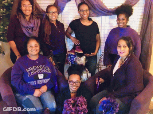 A Group Of Women Are Posing For A Picture And One Of Them Is Wearing A Truman University Sweatshirt GIF