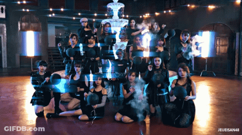 A Group Of Women Are Posing In Front Of A Fountain And A Sign That Says " Jeleisen48 " GIF
