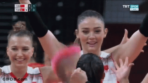 A Group Of Women Are Raising Their Hands In The Air During A Game . GIF