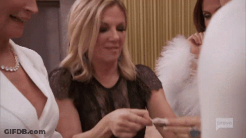 A Group Of Women Are Sitting Around A Table And One Of Them Is Wearing A Bravo Shirt GIF