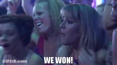 A Group Of Women Are Sitting In A Dark Room With The Words `` We Won '' Written On The Screen . GIF