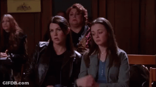 A Group Of Women Are Sitting In A Room And One Of Them Is Holding A Cell Phone . GIF
