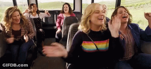 A Group Of Women Are Sitting On A Bus And Laughing . GIF