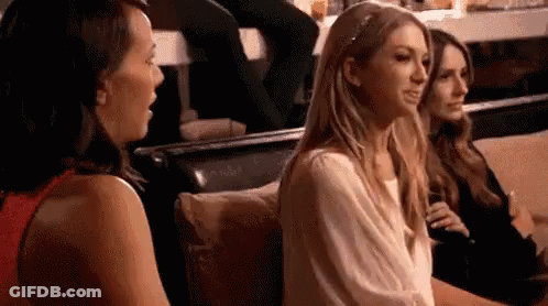 A Group Of Women Are Sitting On A Couch Talking To Each Other In A Restaurant . GIF