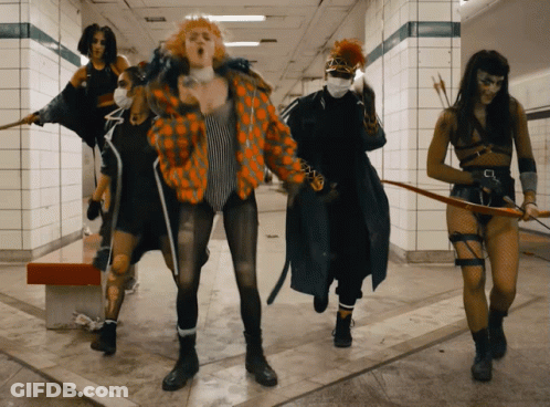 A Group Of Women Are Standing In A Hallway With Arrows GIF
