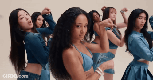 A Group Of Women Are Standing In A Line And One Of Them Is Wearing A Blue Top GIF