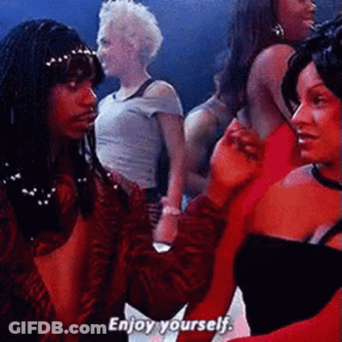 A Group Of Women Are Standing In A Room And One Of Them Says Enjoy Yourself GIF