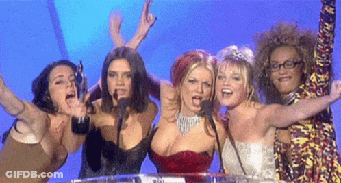 A Group Of Women Are Standing In Front Of A Microphone With Their Arms Outstretched GIF