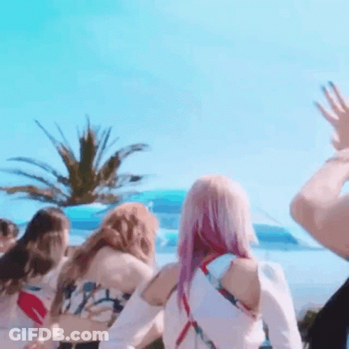 A Group Of Women Are Standing In Front Of A Palm Tree . GIF