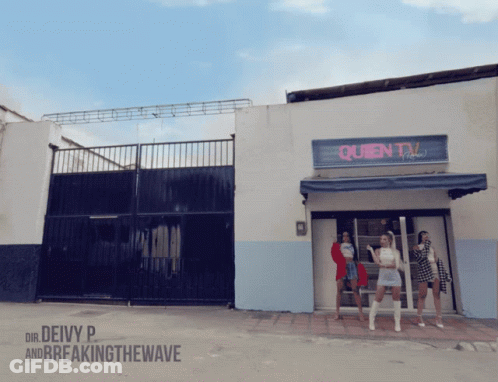 A Group Of Women Are Standing In Front Of A Queen Tv Building GIF