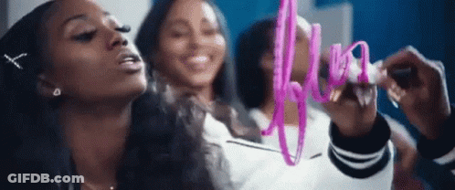 A Group Of Women Are Standing Next To Each Other And One Of Them Is Writing On A Whiteboard With A Pink Marker . GIF