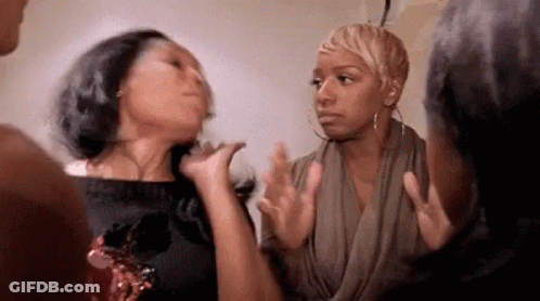 A Group Of Women Are Standing Next To Each Other Having A Conversation . GIF