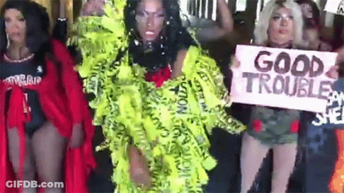 A Group Of Women Are Standing Next To Each Other Holding Signs That Say Good Trouble . GIF
