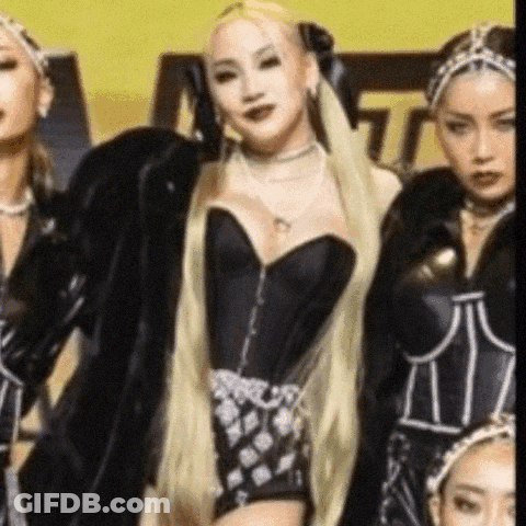 A Group Of Women Are Standing Next To Each Other In A Room . One Of The Women Is Wearing A Black Corset . GIF