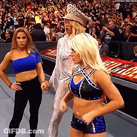 A Group Of Women Are Standing Next To Each Other In A Wrestling Ring . GIF