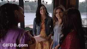 A Group Of Women Are Standing Next To Each Other In Front Of A Window In A Room . GIF