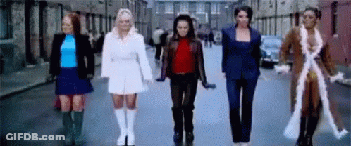 A Group Of Women Are Standing Next To Each Other On A City Street . GIF