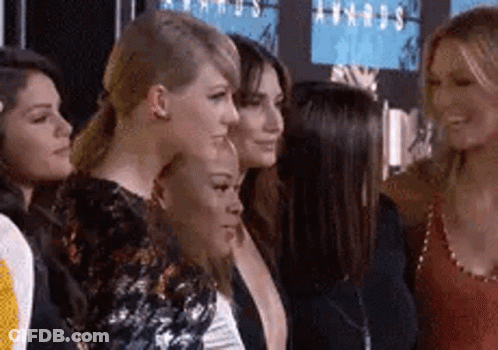 A Group Of Women Are Standing Next To Each Other On A Red Carpet At An Event . GIF
