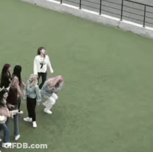 A Group Of Women Are Standing On Top Of A Green Field . GIF