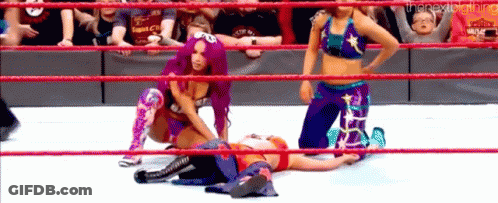 A Group Of Women Are Wrestling In A Ring While A Baby Is Watching . GIF