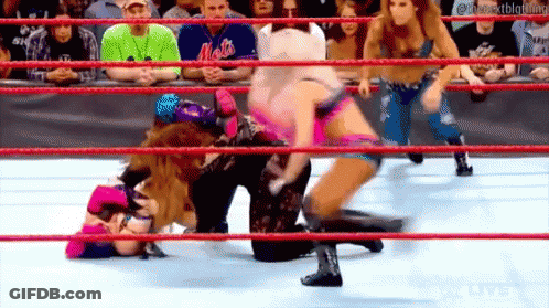 A Group Of Women Are Wrestling In A Ring While A Crowd Watches . GIF