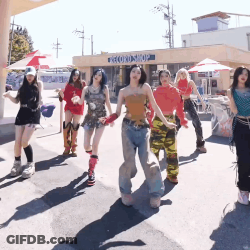 A Group Of Women Dancing In Front Of A Record Shop GIF