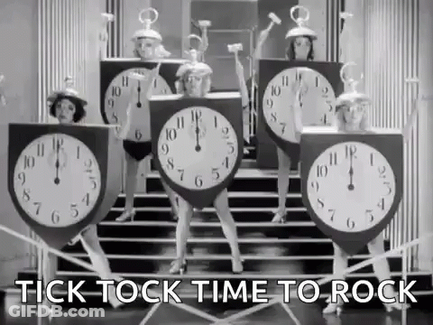 A Group Of Women Dressed As Clocks Are Dancing On Steps . GIF