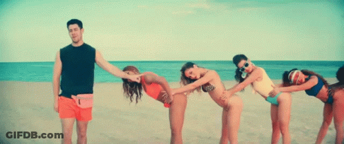 A Group Of Women In Bikinis Are Bending Over To Touch A Man 'S Butt On A Beach . GIF
