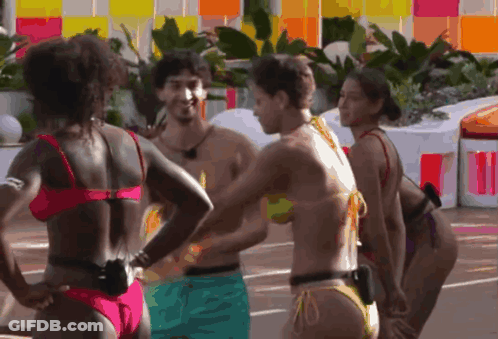 A Group Of Women In Bikinis Are Standing Around A Man GIF