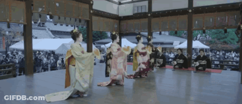 A Group Of Women In Kimonos Are Performing A Dance GIF