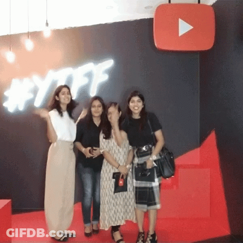 Women Posing In Front Of YouTube Sign GIF