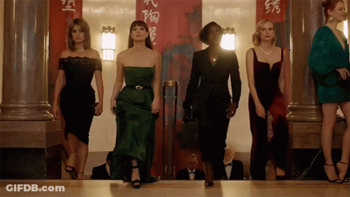 A Group Of Women Standing In Front Of A Red Banner With Chinese Characters GIF