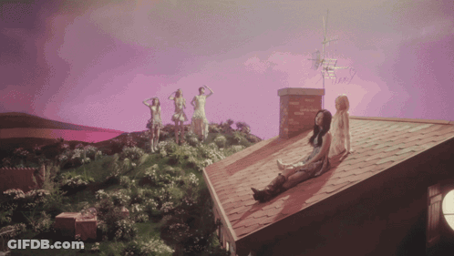 A Group Of Women Standing On Top Of A Roof With A Purple Sky In The Background GIF