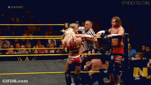 A Group Of Wrestlers Are Fighting In A Wrestling Ring With A Referee Watching . GIF