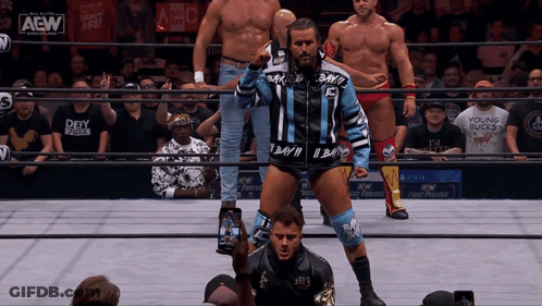 Wrestlers Standing In Ring With AEW Logo GIF