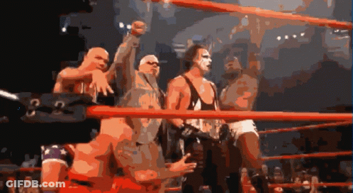 A Group Of Wrestlers Are Standing In A Ring With A Sign That Says G On It GIF
