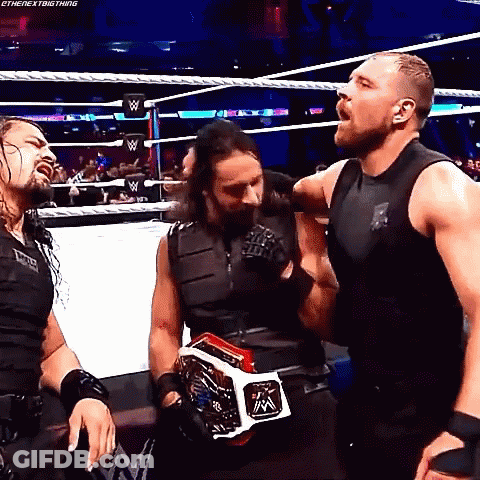 A Group Of Wrestlers Are Standing In A Wrestling Ring . GIF