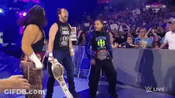 A Group Of Wrestlers Are Standing In Front Of A Crowd And One Of Them Is Wearing A Shirt With The Letter H On It GIF
