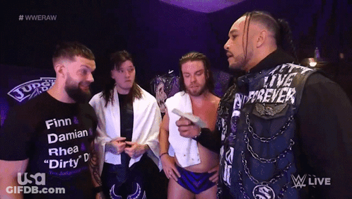 A Group Of Wrestlers Are Standing In Front Of A Screen That Says Wweraw GIF
