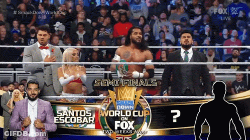 A Group Of Wrestlers Are Standing In Front Of A Sign That Says Smack Down World Cup On Fox GIF
