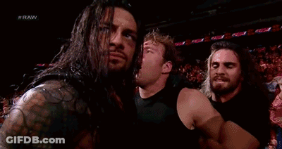 A Group Of Wrestlers Are Standing Next To Each Other In A Stadium . GIF