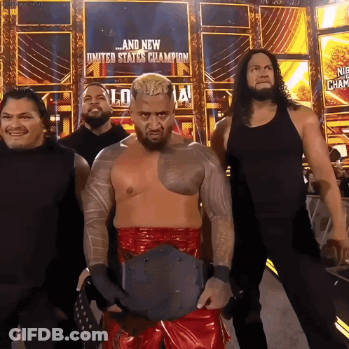 A Group Of Wrestlers Standing In Front Of A Sign That Says United States Champion GIF