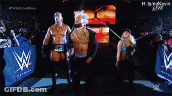 A Group Of Wrestlers Standing In Front Of A Wwe Sign GIF