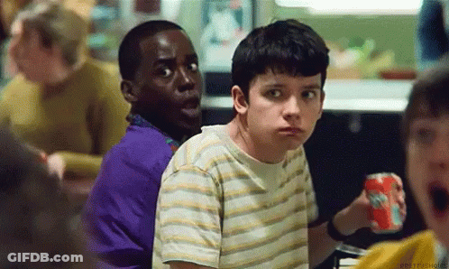 A Group Of Young Boys Are Sitting At A Table In A Restaurant . One Of The Boys Is Holding A Soda Can . GIF
