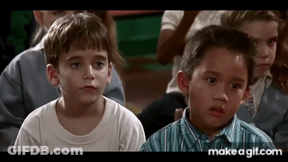 A Group Of Young Boys Are Sitting In A Classroom Looking At Something . GIF