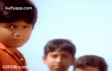 A Group Of Young Boys Are Standing Next To Each Other And One Of Them Is Looking At The Camera . GIF